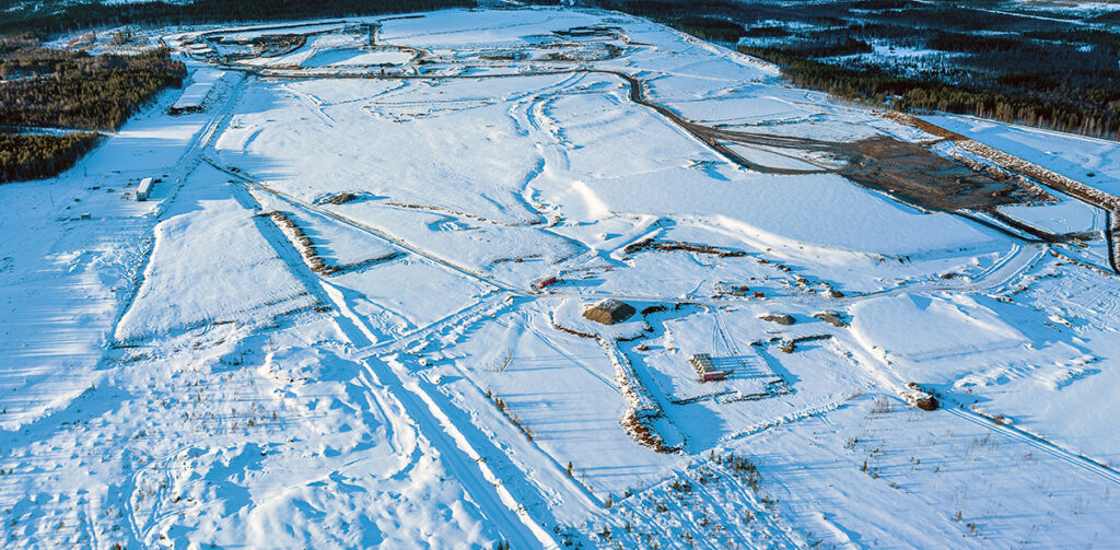 Drönarbild över markområde med snö där marken förbereds för byggnation.